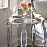 Round side table with silver leaf and glass top.