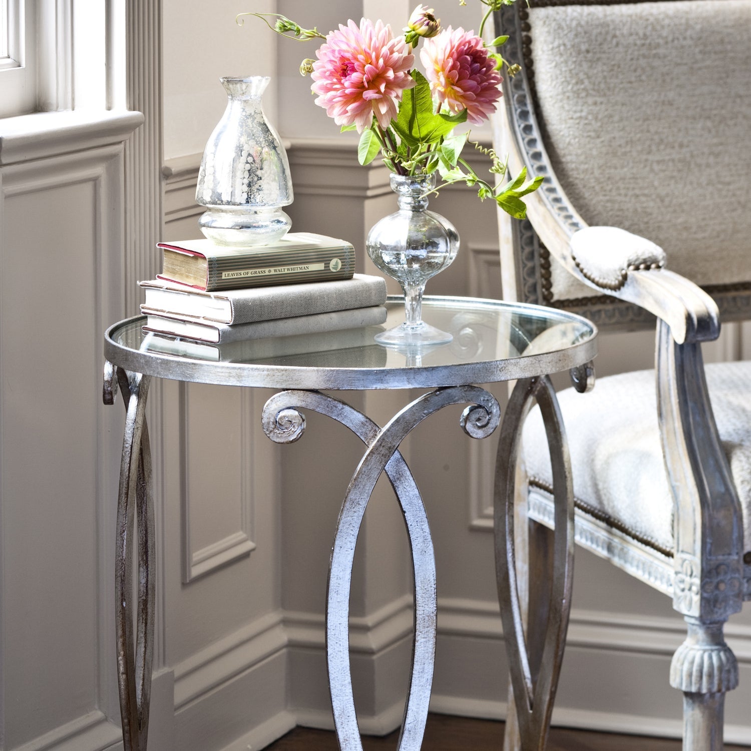 Round side table with silver leaf and glass top.